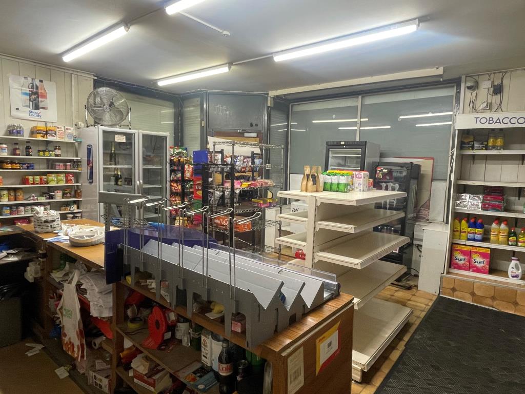 Lot: 57 - MIXED COMMERCIAL/RESIDENTIAL PROPERTY WITH POTENTIAL - Shop floor with shelving and counter area from alternative angle